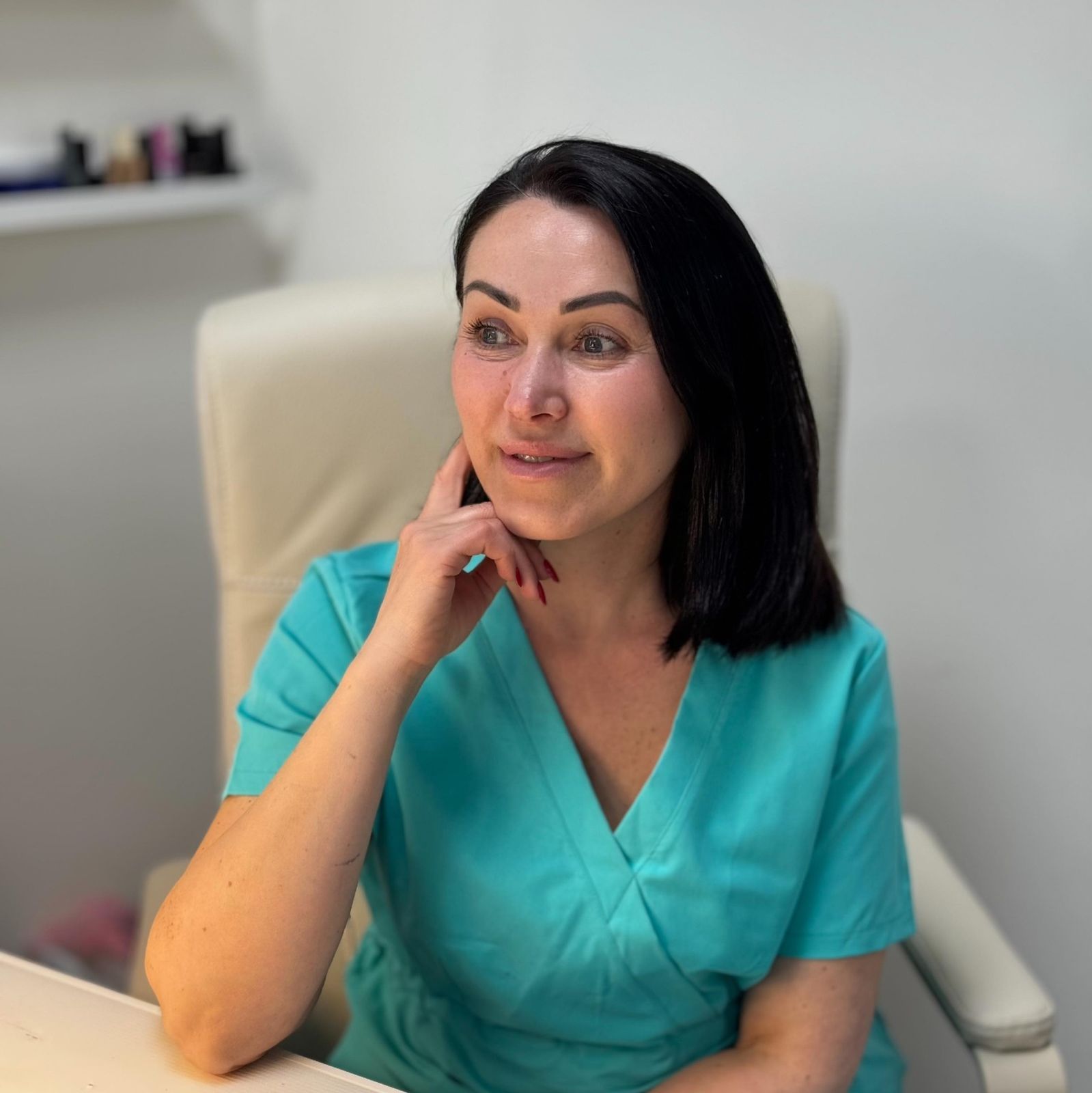 Alena Yashyna aan haar manicuretafel, in een turquoise werkjasje